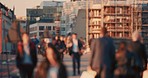 A crowd of blurred people walking over a bridge