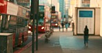 A line of busses driving down the street in the morning