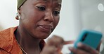 Black woman with smartphone, crying and sad, typing text message or email with reaction to bad news, grief and loss. Depression, mental health and communication of trouble or problems online.