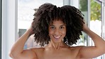 Hair care, beauty and black woman with afro, smile and happiness getting ready in home bathroom .Portrait of model self care, wellness and natural hair routine or healthy growth with cosmetic shampoo
