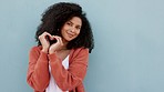 Smile, love sign and happy black woman standing isolated on a blue studio background mockup. Girl, romance and hand heart symbol or shape showing emotion, intimacy or adoration, support or affection.