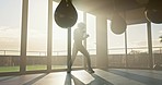 Fitness, boxing and woman training with a punching bag for a fight, match or competition in gym. Motivation, sports and girl athlete doing a MMA or martial arts exercise or workout in studio or dojo.