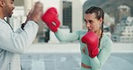 Woman, boxing and coach training, sport and fitness outside with punch, glove and outdoor in a city. Female athlete or boxer practice, workout and exercise for fight, match or cardio with motivation