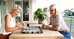 Women play board game on balcony, senior friends at table and enjoy weekend vacation in Australia. Problem solving in senior people on holiday, memory of strategy knowledge and backgammon competition