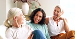 Senior women, friends and reunion at home talking, happy and together for quality time, communication and bonding on living room couch. Females laughing about comic conversation in retirement home
