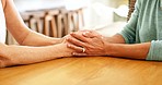 Support, love and senior friends holding hands for empathy, retirement care and hope at their home table. Trust, healing and helping hands sign of elderly people with gratitude or sorry about news