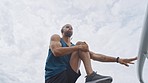 Fitness, man and marathon runner stretching legs for training, cardio exercise or workout on the road. Wellness, focus or sports athlete with headphones in a body warm up for a running challenge 