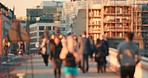 Blurry crowd of people crossing a bridge while a woman runs