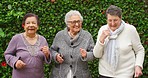 Phone, earphones and elderly friends dancing to music on radio or audio podcast together in backyard garden. Happy, retired and senior women dancing, streaming online and comic happiness for fun
