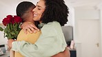 Flowers, anniversary and man with a surprise for his wife with love, romance and care at their home. Happy, smile and romantic husband with roses for celebration hugging a woman in the living room.