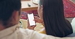 Couple, phone screen and mobile app in living room for social media, online shopping and reading internet blog post, website and technology. Back view, man and woman relax on sofa with smartphone 