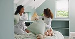 Mother, child and smile for pillow fight on bed for morning happiness, playful fun and quality time together. Happy parent, child laughing and crazy, funny and comic bonding with pillows in bedroom