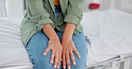 Woman, hands and nervous in hospital clinic for pregnancy test results, healthcare report or cancer surgery approval. Zoom, medical patient and person anxiety, mental health and ptsd stress on er bed