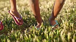 Kids, summer and feet jump on grass with flip flops for holiday, fun and childhood together. Freedom, vacation and children jumping on lawn with happiness in sunshine on nature walk.


