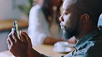 Black man in cafe, phone and typing while on lunch break, relax and reading online notification, social media post and mobile app. Guy with smartphone, technology and remote working in coffee shop 