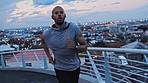 Black man, runner and athlete rest on bridge in city for cardiovascular fitness, healthy body exercise and cardio workout. Healthy athlete, runnning on street and resting for a marathon race training