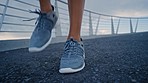 Shoes, fitness and person workout, exercise and training outdoor on asphalt bridge or road for healthy lifestyle. Feet, sneaker and body warmup with cardio for wellness, health or commitment for race