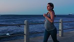 Pregnant woman running at sunset, beach and exercise for healthy maternity, strong body or sports action. Pregnancy, fitness and lady for energy, cardio training and wellness at ocean, sea and nature