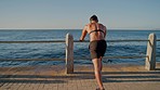 Man, fitness and stretching by sunset beach, ocean or sea in healthcare workout, cardiovascular training or muscle pain relief. Runner, sports athlete and person in warm up for sunrise body exercise