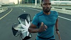 Running parachute, fitness and black man exercise in city street for cardio workout, sports training or wellness goals. Urban runner, challenge and air resistance for marathon, power and fast athlete