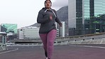Fitness, earphones and fat black woman running in city for weight loss, health or wellness. Sports, obesity and plus size female training in street in winter while streaming radio, music or podcast.