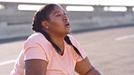 Fitness, tired or plus size black woman breathing on a city road resting or relaxing on a workout, exercise or training break. Fatigue, breathe or young runner exercising to lose weight or burn fat 