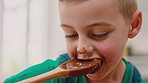 Baking, chocolate and face of child with spoon to lick, taste and eating mixture of cake, muffins or cupcakes. Family home, childhood and young boy enjoying dessert food in kitchen with dirty mouth