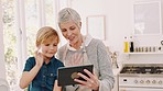 Family, tablet and grandmother with child on video call wave for quality time, bonding and online chat. Communication, love and young boy with grandma in kitchen enjoy weekend together in family home
