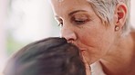 Family, love and grandmother kiss girl on forehead for affection, comfort and compassion in family home. Loving, happy and grandma kissing child for quality time, bonding and care on weekend together