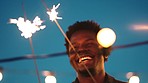 Black man, laughing or dancing and sparkler in night rooftop party, New Year celebration or birthday social gathering on building. Smile, happy or dance people with fireworks in freedom energy motion