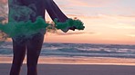 Sunset, beach and woman with smoke bomb on vacation, holiday or summer trip. Relax, freedom and back view of female with smoker flare outdoors on seashore, having fun and enjoying quality time alone