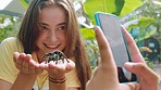 Tarantula, spider and teenager with a mobile phone picture at a animal sanctuary or wildlife zoo. Smile, happiness and brave teen, gen z and friends with a cellphone capture photo for social media