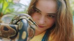 Snake, animal and girl at zoo, park and excursion in nature, petting zoo and wildlife for learning, education and fun. Happy, young and fearless teenager holding reptile animal in ecology environment