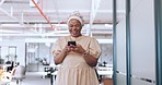 Black woman, phone and communication with a business contact while walking in a creative office laughing about funny meme notification. Happy african employee using mobile data on social network