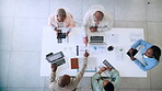 Business people, meeting and planning strategy above with technology in marketing, advertising or analytics at the office. Top view of marketing team in discussion with data, information or analysis
