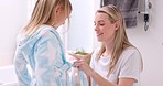 Girl, mother and bathrobe in a bathroom for cleaning, wellness and hygiene in their home together. Children, washing and woman help child with gown after shower, bond and relax while talking