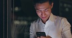 Smartphone, night and business man networking on global app, happy notification or social media chat. Smile of corporate, asian worker using phone or cellphone in dark office on digital communication