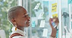 Thinking, brainstorming and black woman with smile at moodboard writing notes on glass wall for creative startup idea. Strategy, planning on sticky note at workshop and future business project goals.