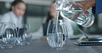 Business people, hands and pouring glass of water for meeting, discussion or planning on a table. Hand of thirsty employee filling cup half full on office desk for hydration in preparation for speech