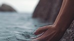 Woman hands in the water from the ocean waves with a health, relax and peaceful lifestyle. Closeup of a girl touching the calm, clean and soothing river, sea or lake to wet her skin in nature.