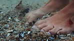 Feet, sea and shells with the barefoot woman in the ocean standing with toes in the current, tide and flow. Water, nature and freedom with a female on holiday, vacation or getaway by the beach