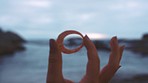 Girl hand with view of ocean through sea shell while on vacation or holiday to water seashore location. Earth, nature and hands of woman enjoy peace, freedom and relax at shore for calm outdoor day