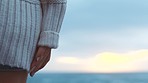 Hands, sunset and horizon with a woman on the beach and the sky, ocean and clouds in the background closeup. Sea, view and summer with a female standing alone outside in nature during the day