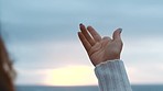 Hands, freedom and nature with the hand of a woman moving outside with the sea, sky and horizon in the background. Closeup of a female moving her palm and fingers against a beautiful view at sunset