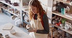 Pottery, art and design woman artist in a home studio working on creative work. Ceramic arts designer or student at a learning workshop or house preparing a clay stencil pattern on a vase project