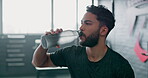 Drinking water, fitness and tired man in gym workout, training and wellness challenge, goals and health. Liquid bottle for nutrition, diet pr exercise energy of sports, athlete person or body builder