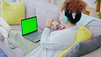 Black woman, sofa and headphones for dancing with laptop, green screen mockup and relax in home living room. Gen z girl, streaming and audio electronics for radio, dance or listen to song on internet