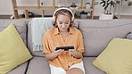 Top view, Asian woman on sofa and headphones with cellphone, streaming music and funny videos. Japan, female and lady with smartphone, headset and connection for social media and relax in living room