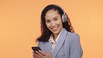 Headphones, cellphone and woman face isolated on orange background for music streaming app and listening to audio. Young black person with phone, electronics or headphone sound technology in studio