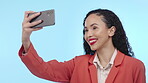 Selfie, business woman and smile in studio for social media profile picture and motivation. Happy model person with phone in hand on blue background for content creator post or video memory online